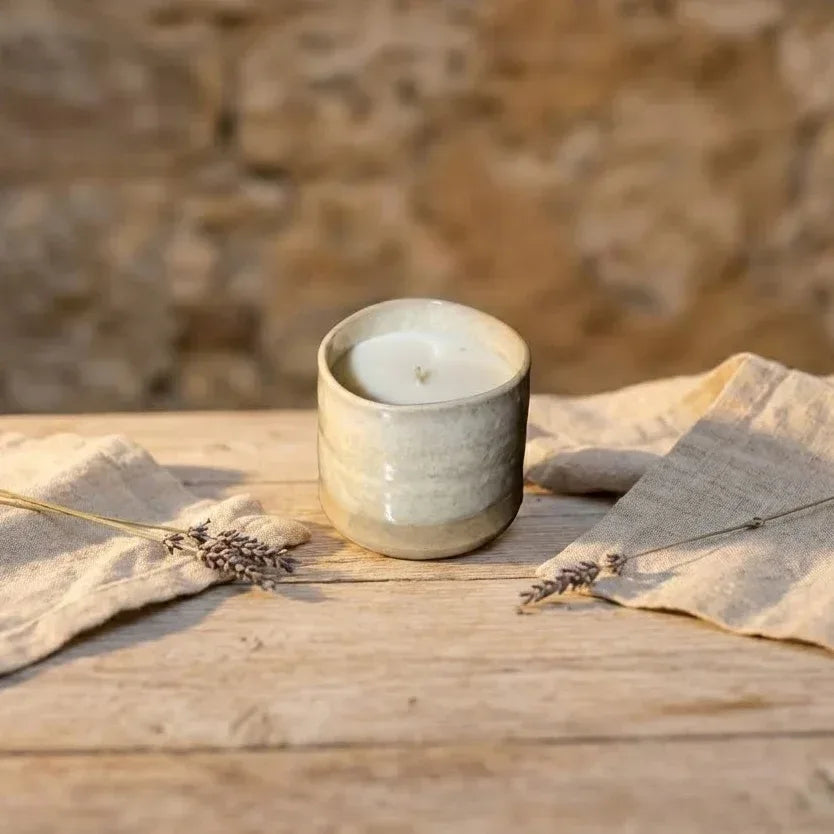 Bougie céramique rechargeable artisanale émaillée beige crème. Objet déco pour une ambiance chaleureuse et nature en Provence, posée sur du lin avec lavande séchée. format-90g